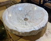 Lavabo redondo de mármol rosa.