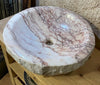 Lavabo redondo de mármol rosa.