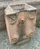 Fuente de piedra caliza rojiza de pared.