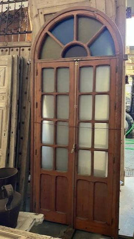 Puerta madera de medio arco con cristales