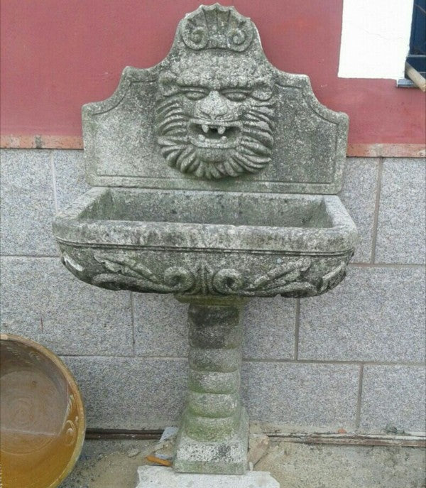 Fuente de granito con cabeza de león.