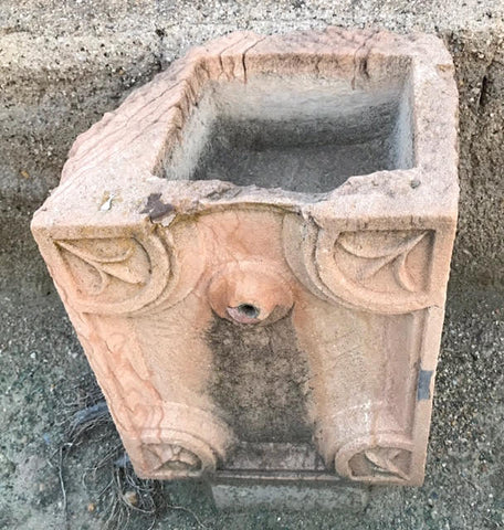 Fuente de piedra caliza rojiza de pared