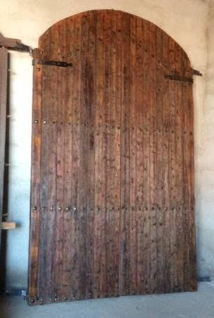 Portón de madera restaurado de medio arco