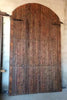 Portón de madera restaurado de medio arco.