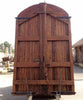 Portón de madera restaurado de medio arco.