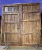 Portón de clavos restaurado con puerta de paso.