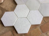 Losa de mármol hexagonal abujardada.