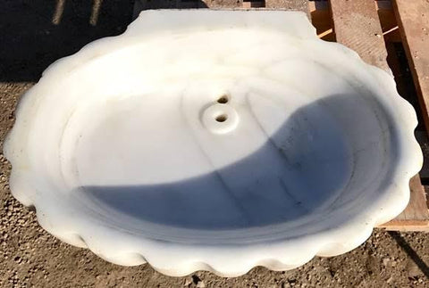Pila bautismal de mármol con forma de concha