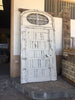 Puerta antigua con lucernario y rejas.
