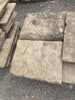 Losas de piedra gris ocre abujardada.