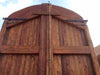 Portón de madera restaurado de medio arco.