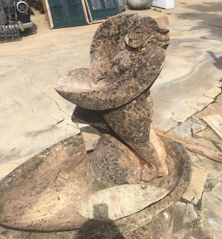 Fuente de piedra con caras de mujeres picassianas